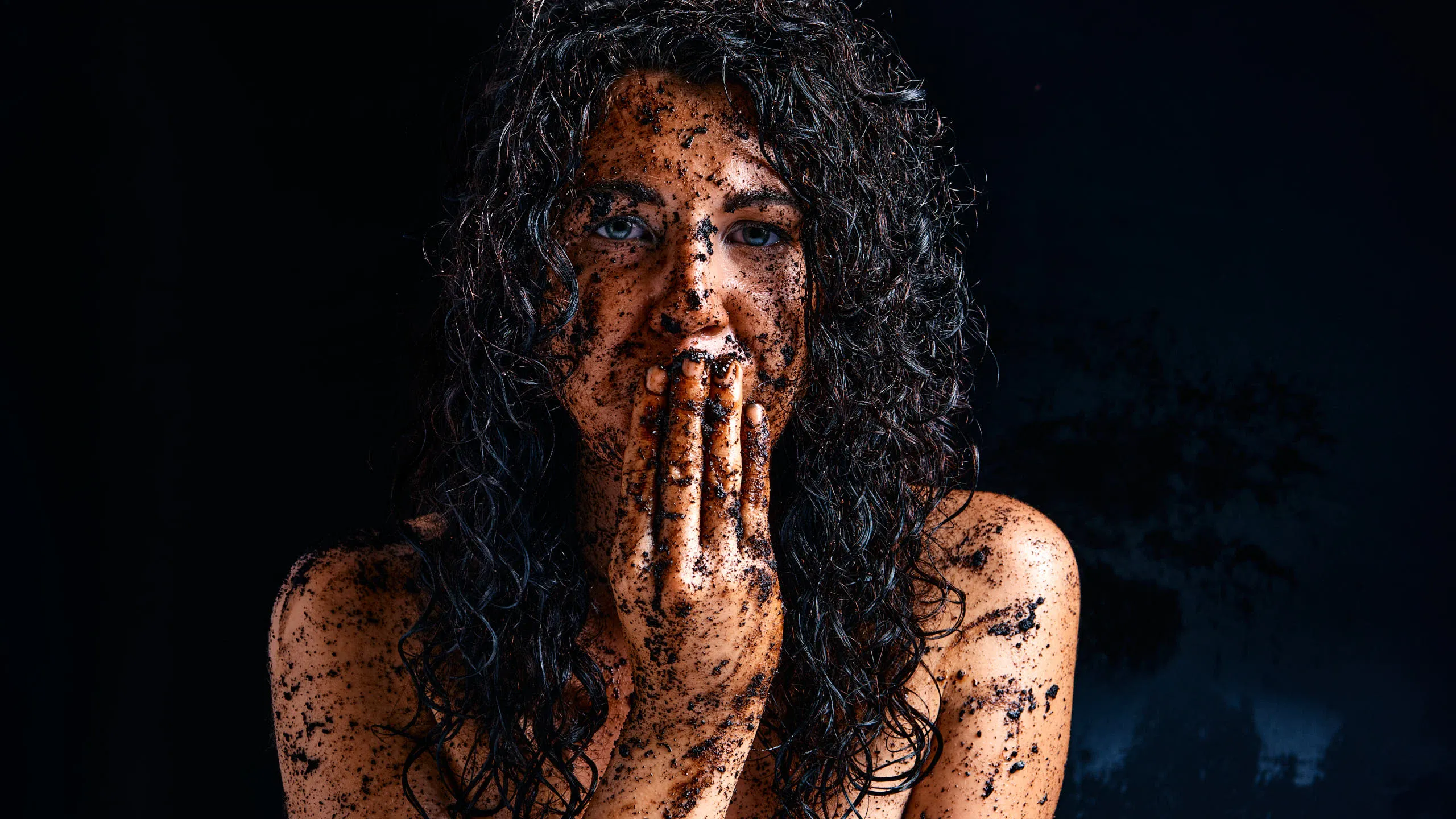 Close-up portrait of Gia Ren with a dirty, messy aesthetic, expressive facial features, and fingers near her mouth, conveying a raw and provocative artistic mood.