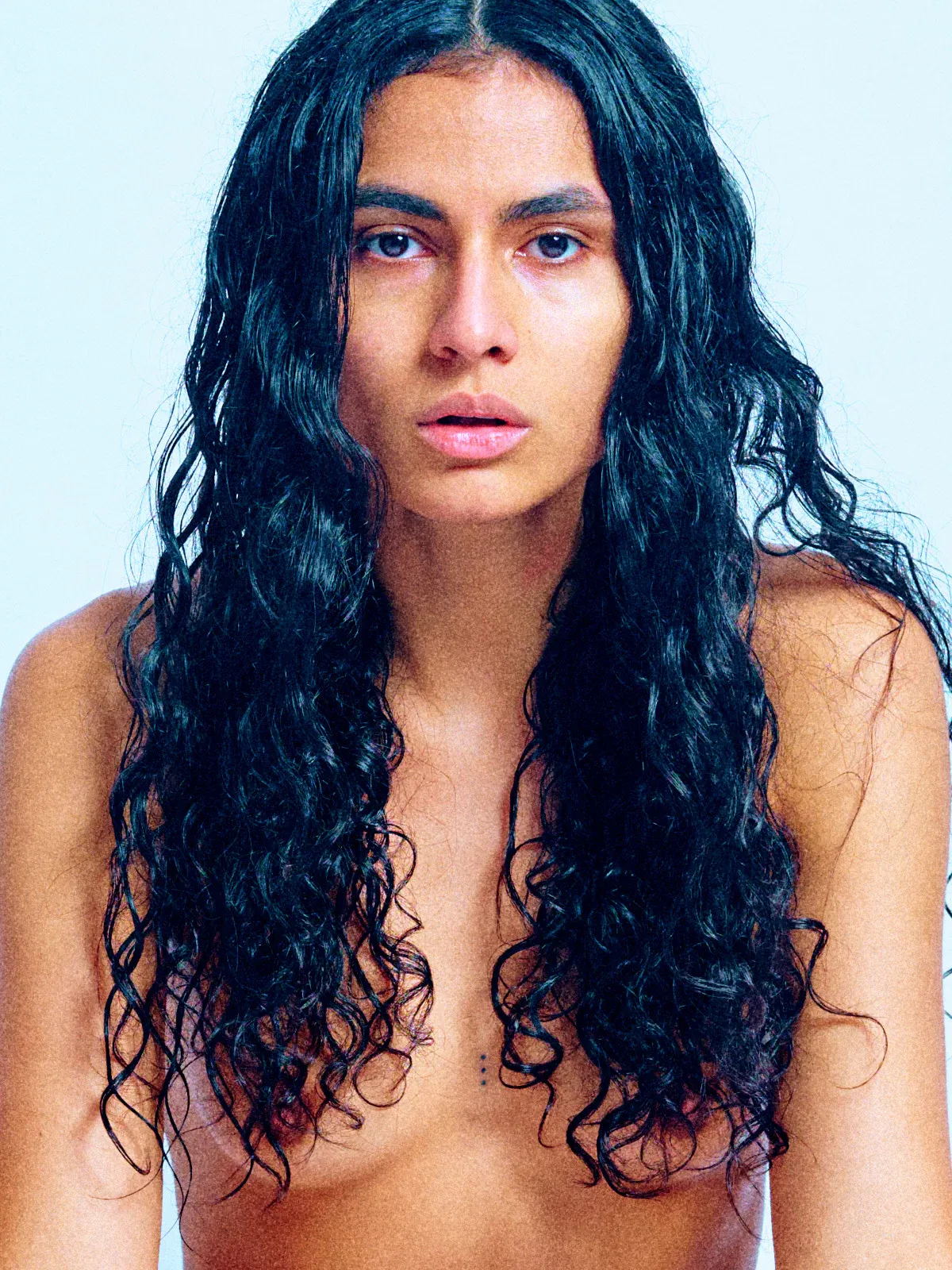 Brown Sugar nude on a soft blue background, captured in elegant, flowing movement and cinematic light