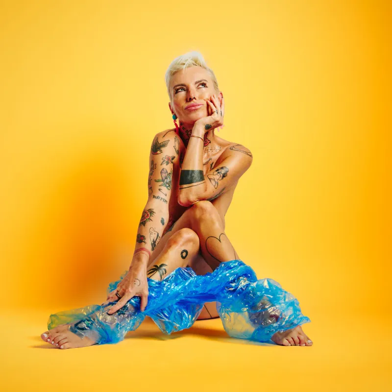 Lu Epic in the Colors series, nude with blue see-through pants and high-contrast yellow background