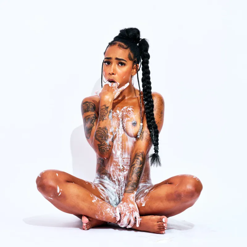 Fine art nude photograph of African Beauty with white cream highlighting her curves and tattoos