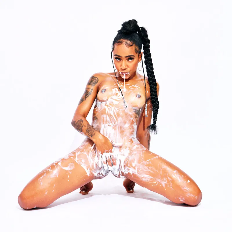 Fine art nude photograph of African Beauty with white cream highlighting her curves and tattoos