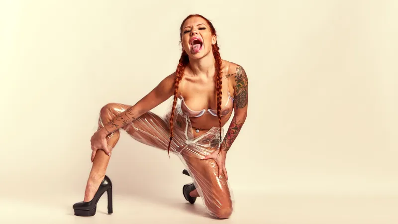 Red Yuliya’s braided hair and transparent plastic outfit highlighted in provocative art photography from the Scarlet Transparency series.
