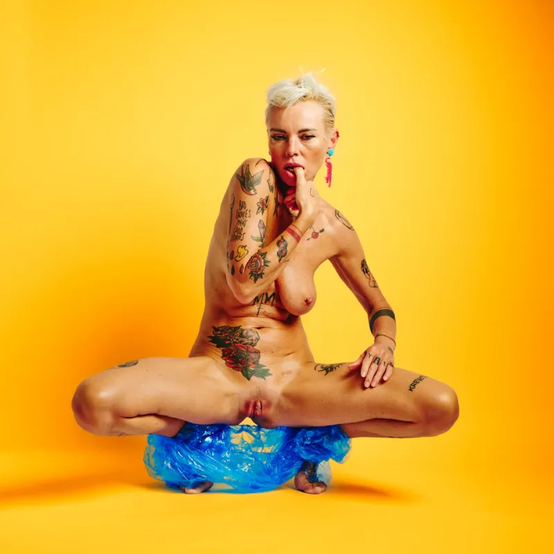 Lu Epic in the Colors series, nude with blue see-through pants and high-contrast yellow background