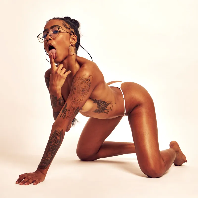 African Beauty nude in white thong in Soft Seduction, showcasing tattoos and curves
