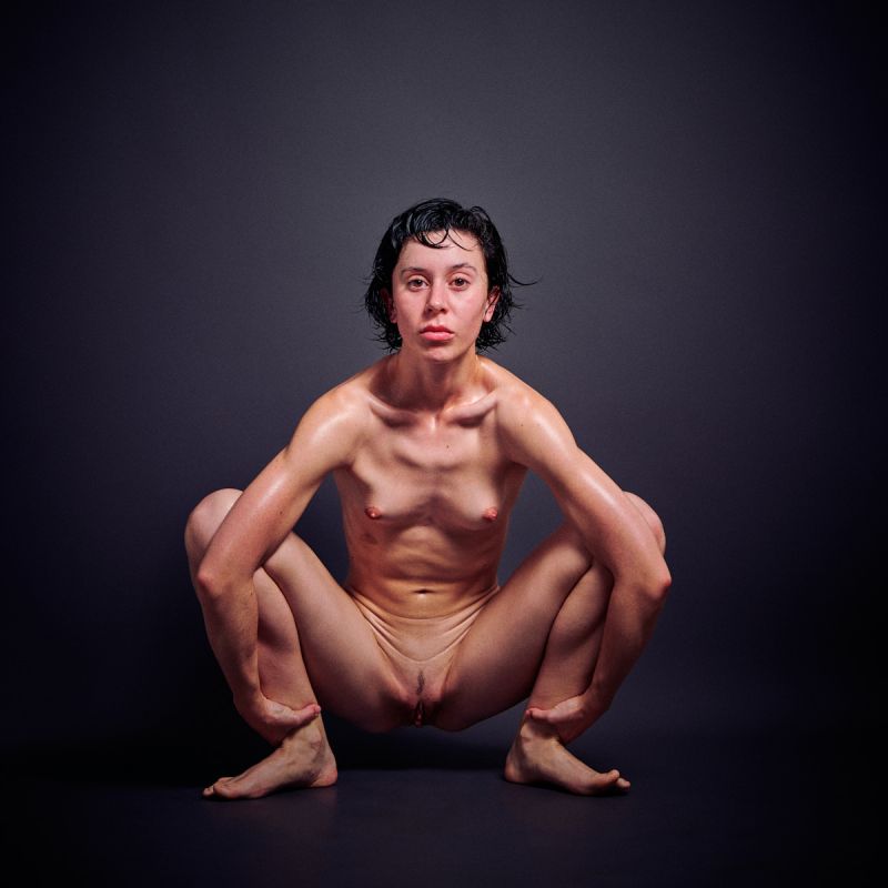 German model Ulah Bauer Nude oiled skin extreme explicit pose dark backdrop Barcelona photographer Cinaed Dane