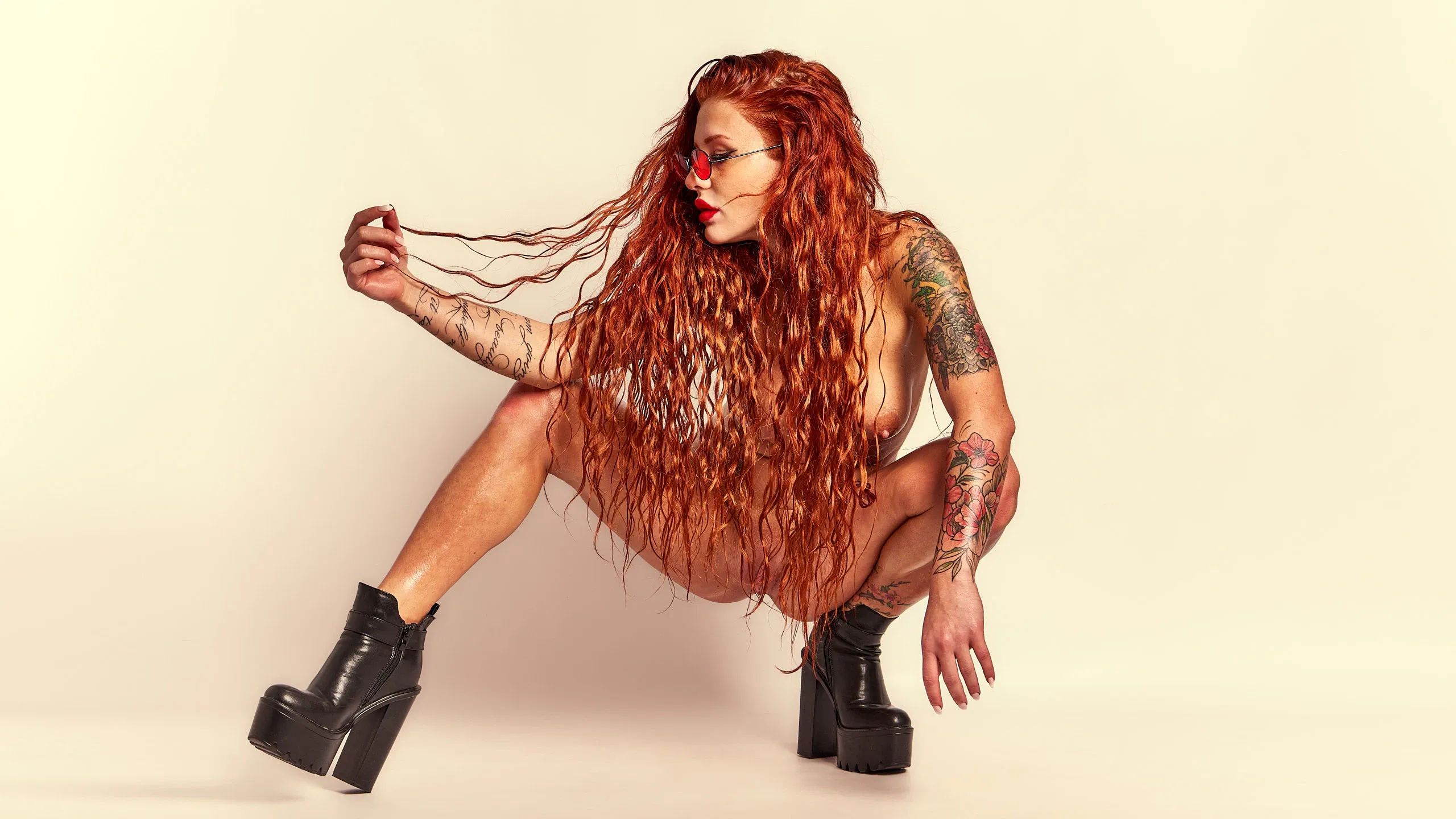 Red-haired model Red Yuliya striking bold, provocative gestures in the Red Flame art photography series.