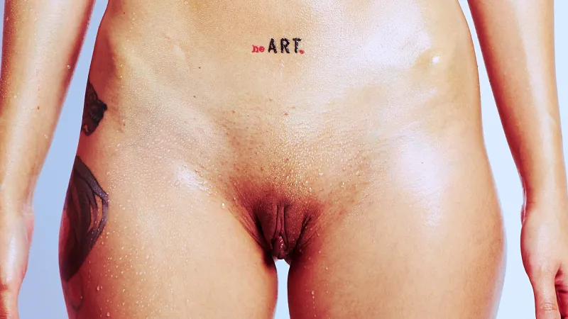 Nude art portrait of Kiki with wet skin, tattoos, and athletic swimmer styling.