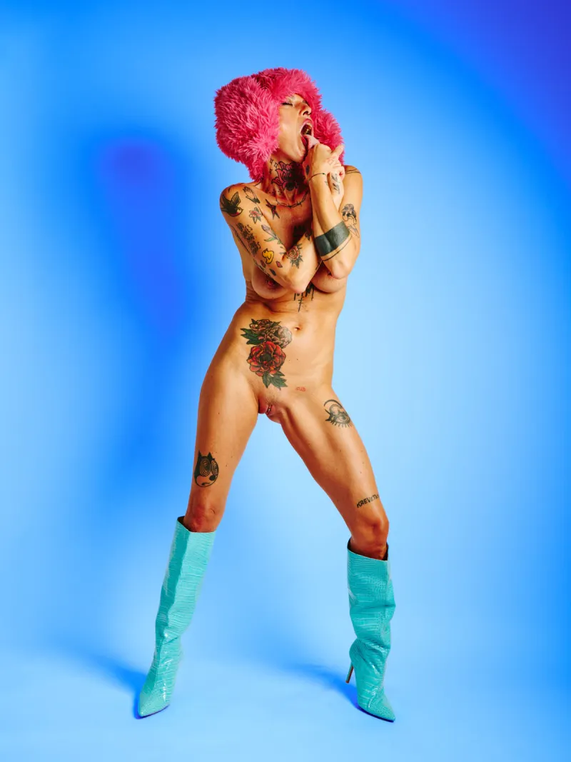 Nude tattooed model posed in Red Rabbit series with oversized red rabbit ears